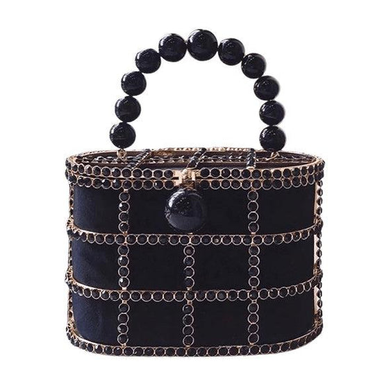 gold cage style bag, embellished with black jewels that are set in gold tone hardware and secured with a black pearl clasp