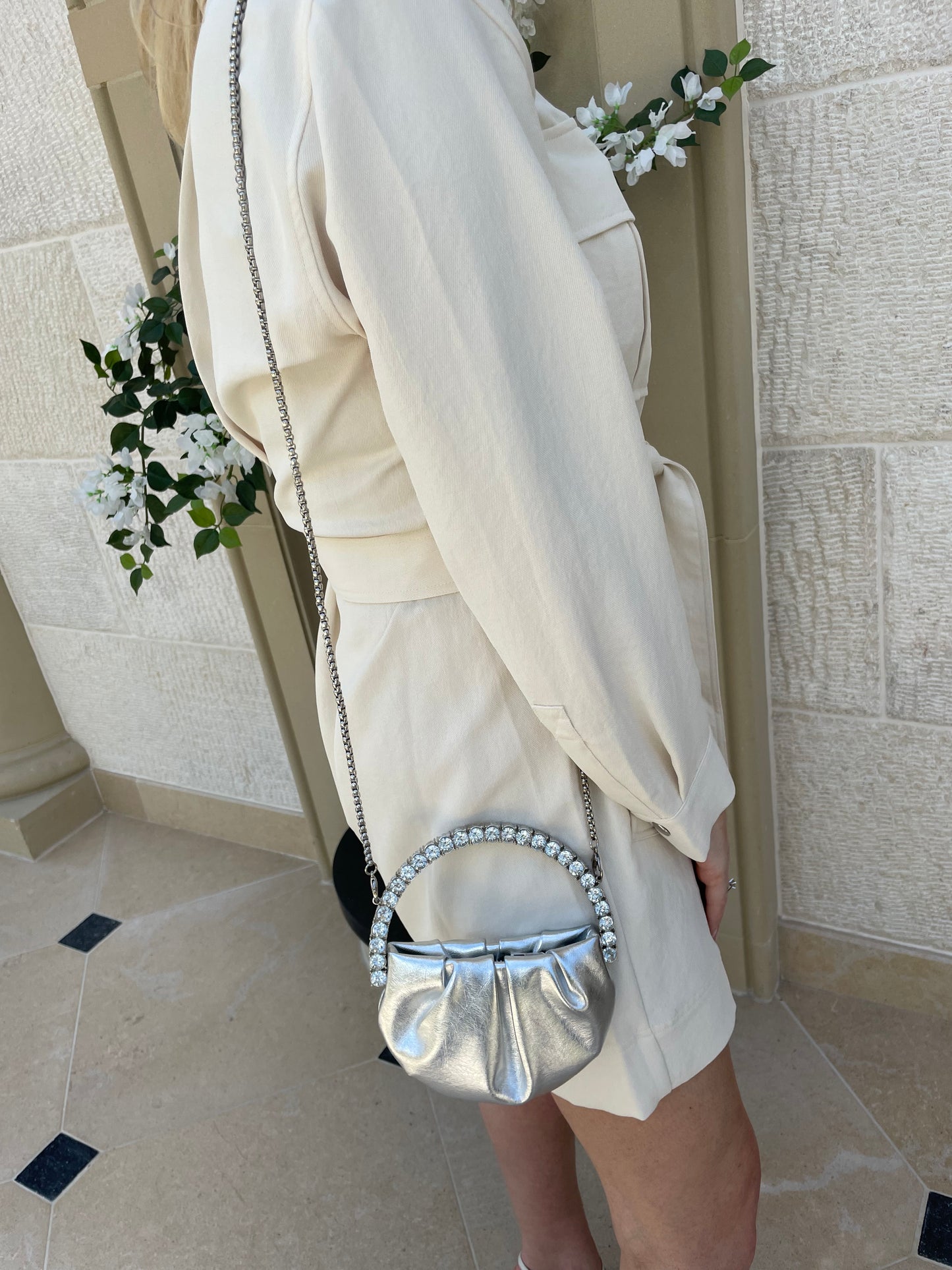 Lady wearing the Silver Mini Clutch bag with silver chain-shoulder strap on her side